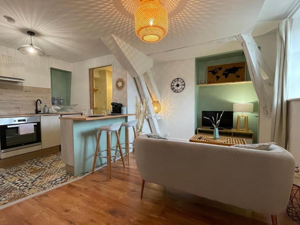 a living room with a couch and a kitchen at Le Cocon - Parking - Hyper Center in Chartres