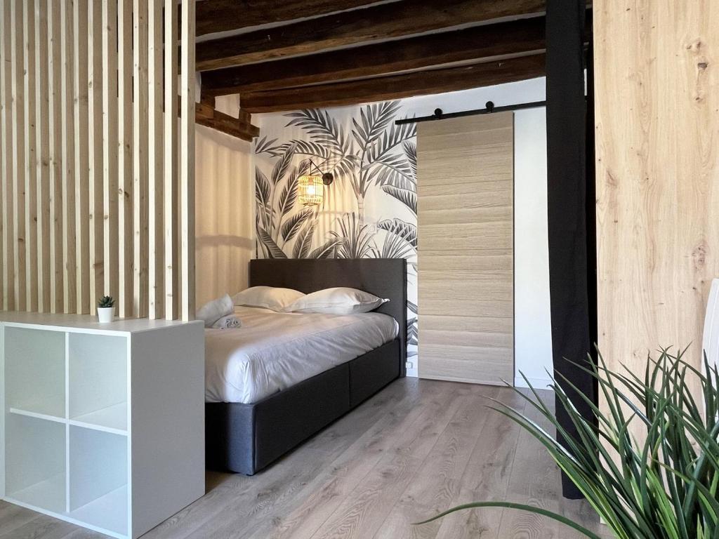 a bedroom with a bed and a wall with a plant at L'Eure Tranquille in Chartres