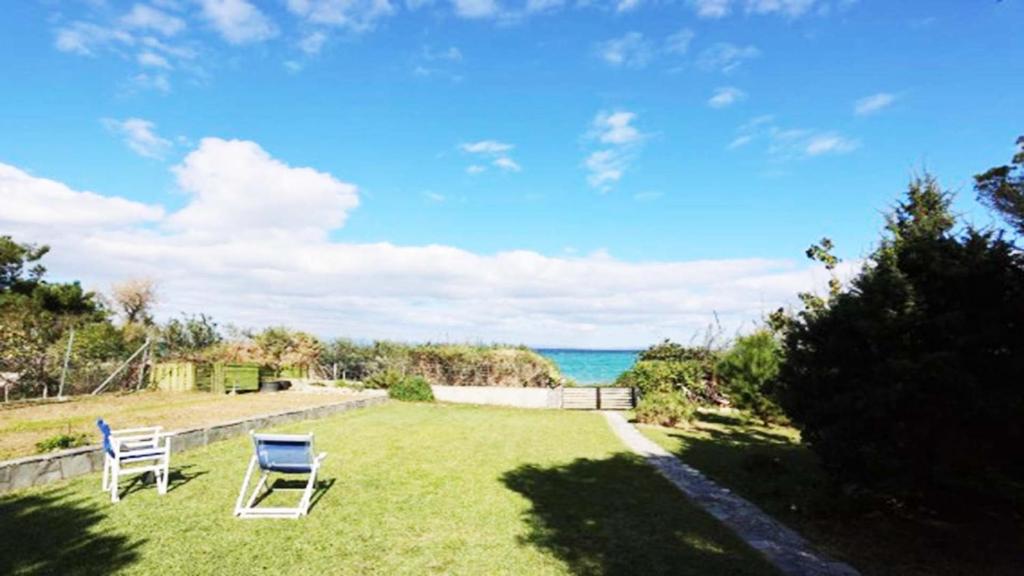 Beach Front Villa in Polychrono في هانيوتي: ساحة مع كرسيين والمحيط