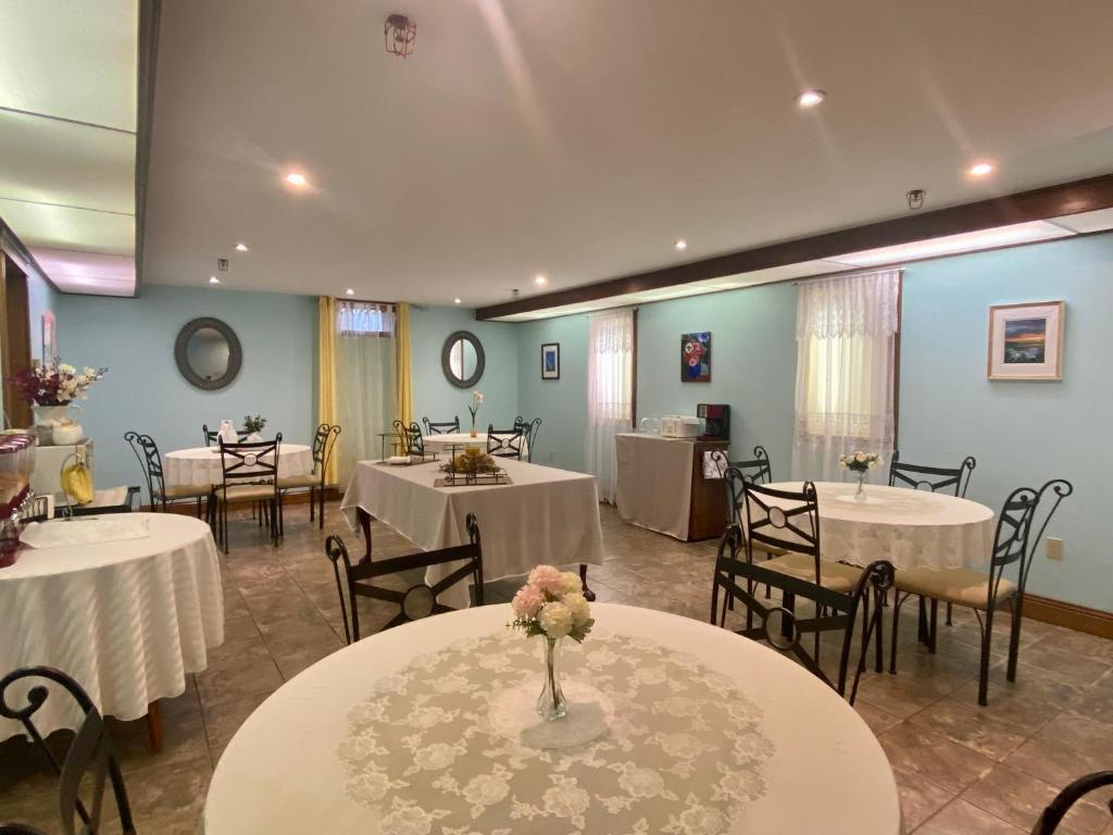 Inn on the Harbour في شارلوت تاون: غرفة مأدبة مع طاولات وكراسي مع مفارش بيضاء