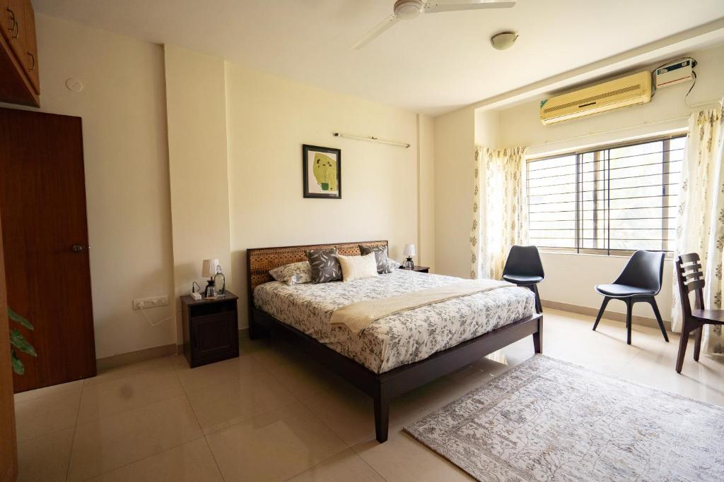a bedroom with a bed and a window at Luho 306 in Bengaluru