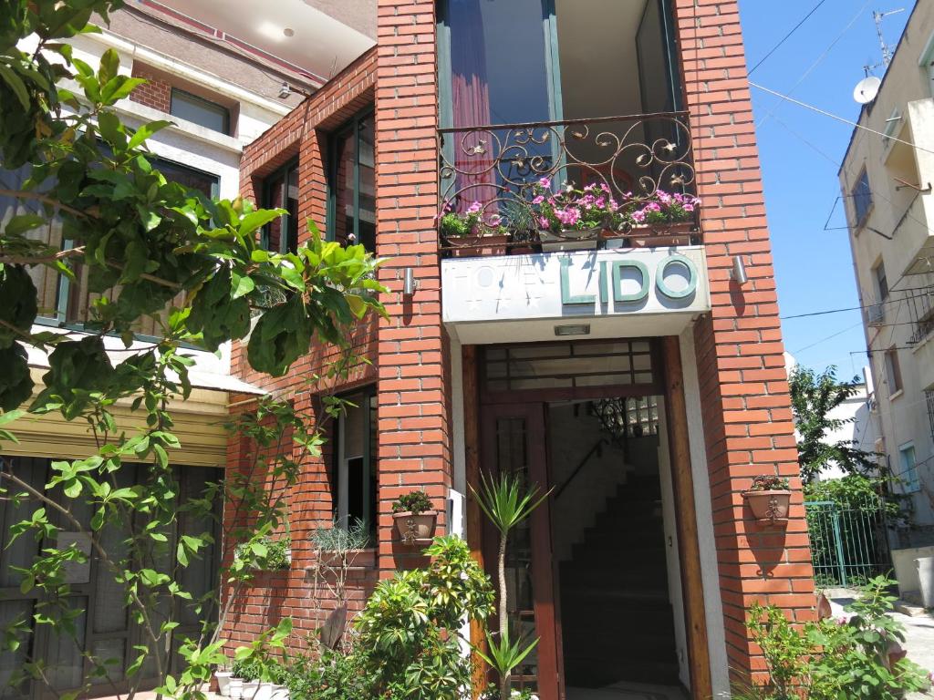 un edificio di mattoni con un cartello che dice "halo" di Hotel Lido a Durrës