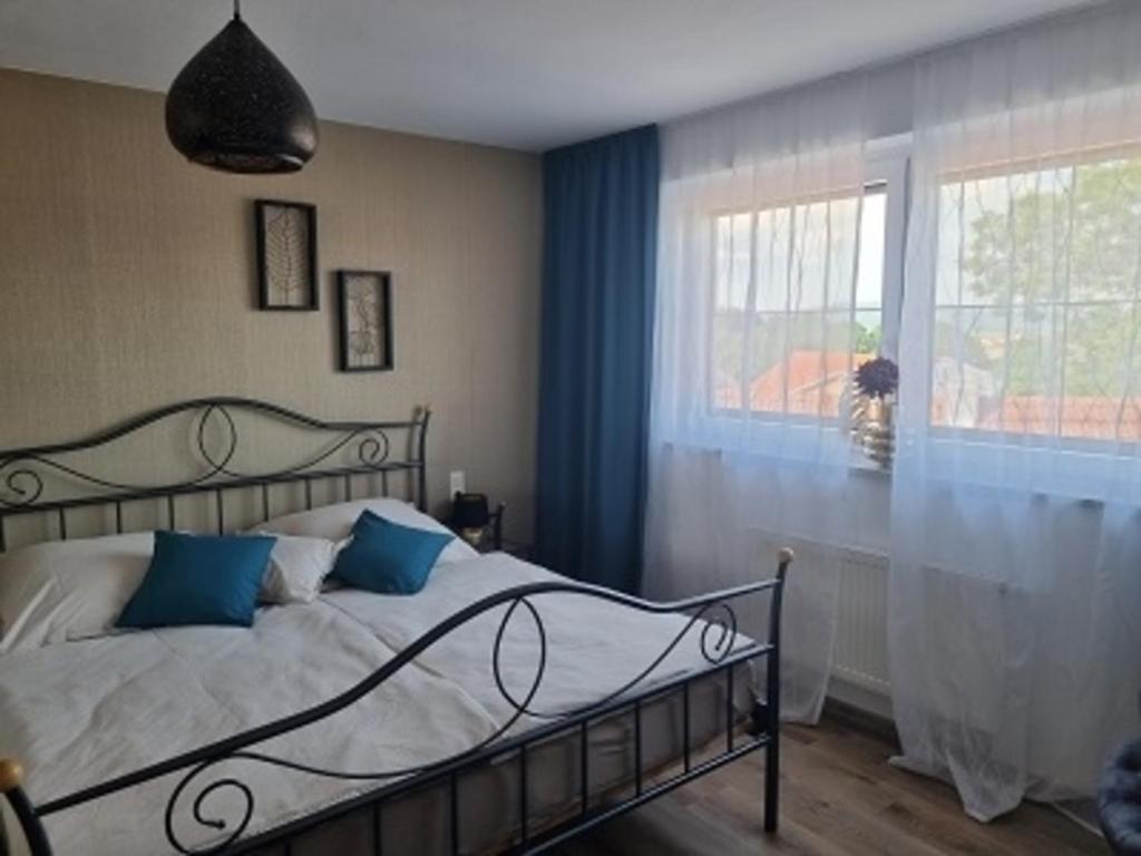 1 dormitorio con 1 cama con cortinas azules y ventana en Ferienwohnung Augustin, en Kirchberg
