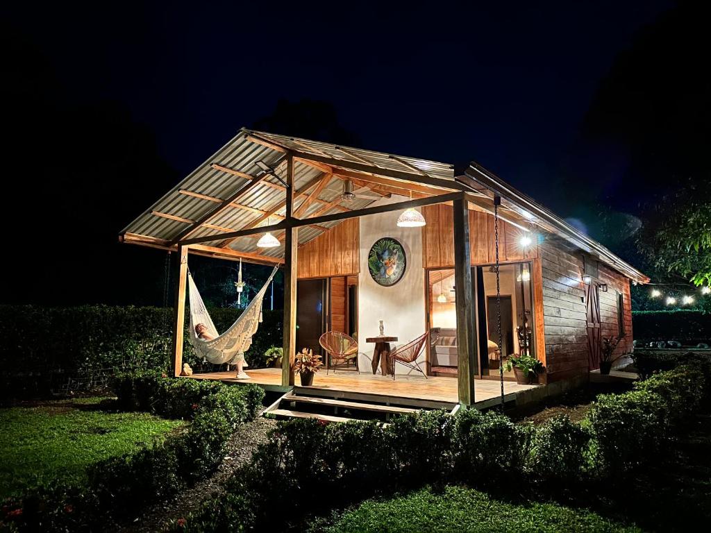 een klein huis met een hangmat in de nacht bij Romantic Private Cabin in the Forest, Bungalows Tulipanes in San Ramón