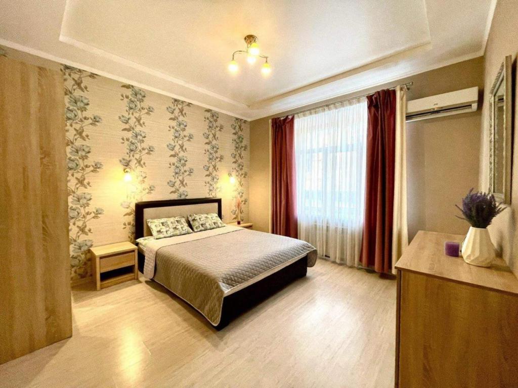 a bedroom with a bed and a large window at Pushkinskaya street in Kharkiv