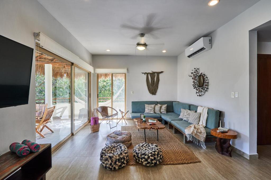 ein Wohnzimmer mit einem blauen Sofa und einem Tisch in der Unterkunft Stunning Penthouse with Private Rooftop in Aldea Zama in Tulum