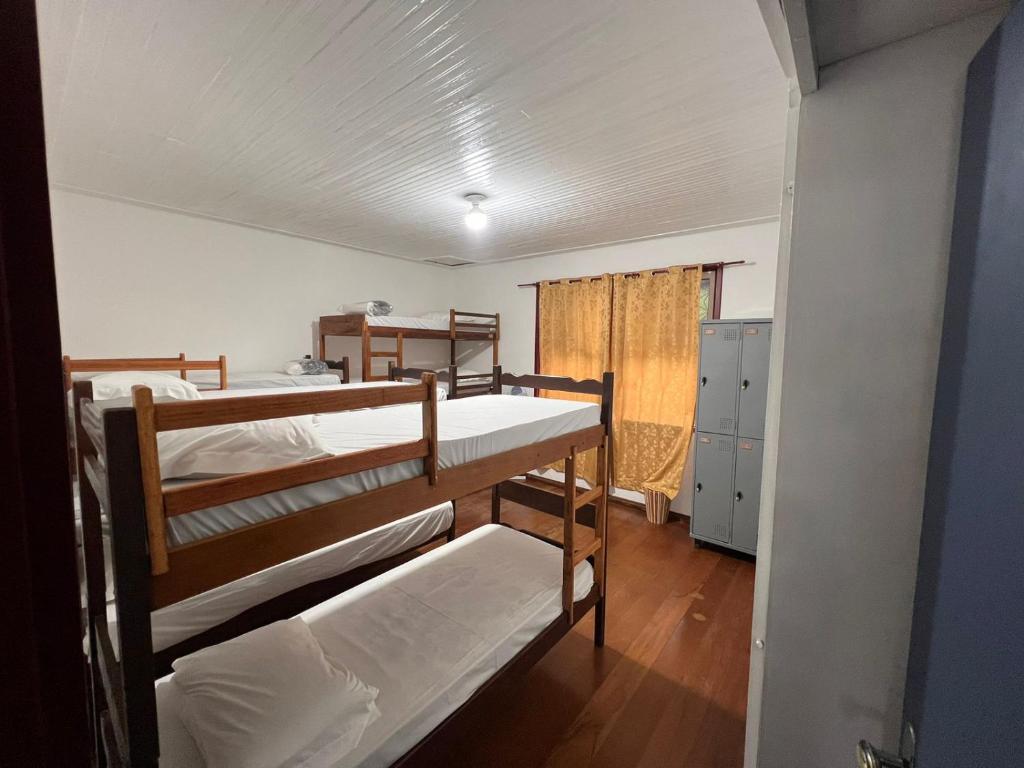 a room with two bunk beds and a hallway at Pertin da Praça Hostel in Ouro Preto