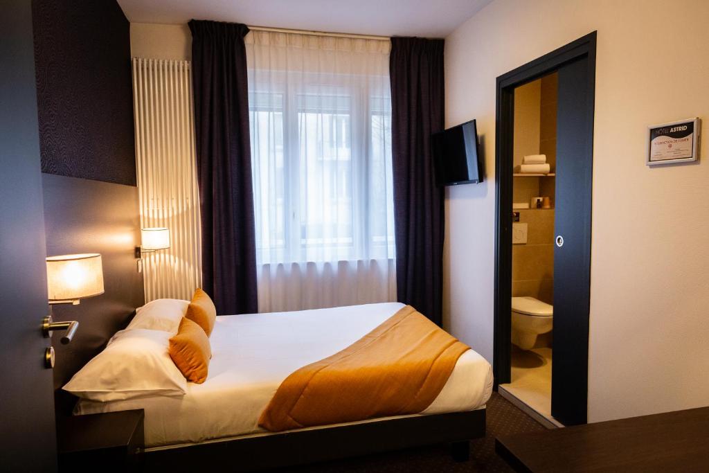 une chambre d'hôtel avec un lit et une fenêtre dans l'établissement Hotel Astrid Caen centre, à Caen