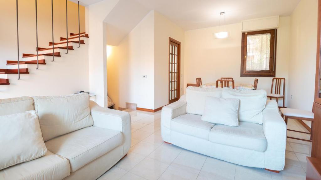 a living room with two white couches and a table at Villino Octagon in Elmas