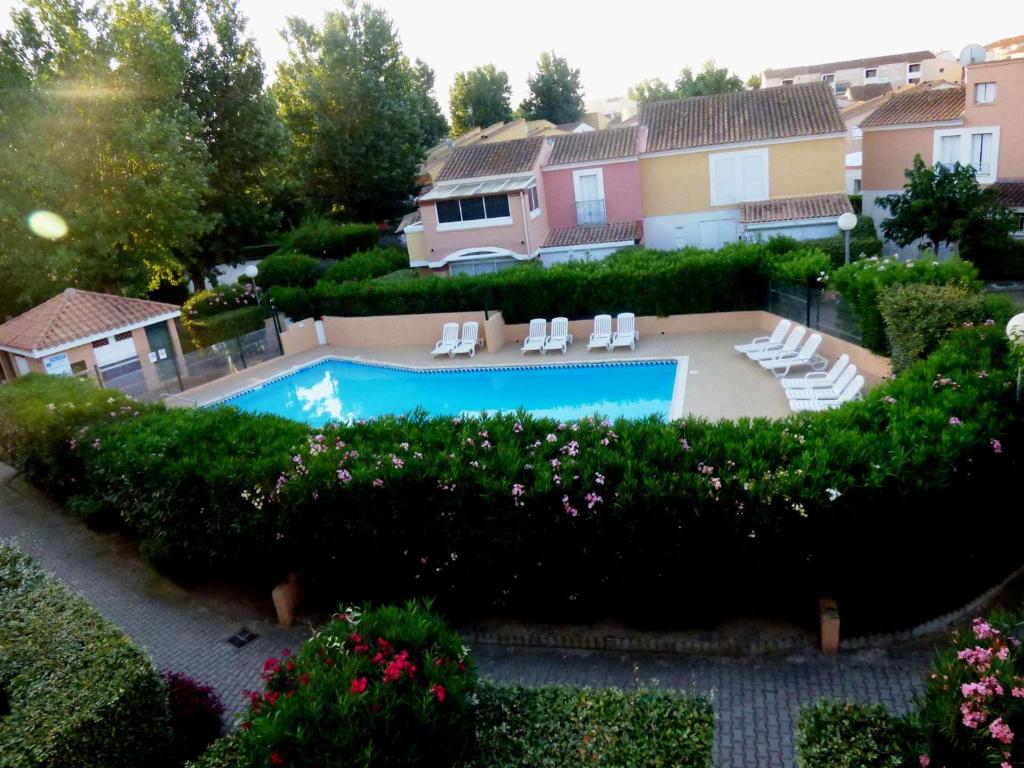 - une vue sur la piscine dans la cour dans l'établissement Appartement cosy avec piscine, proche commodités et plages, idéal pour familles - FR-1-387-164, à Marseillan
