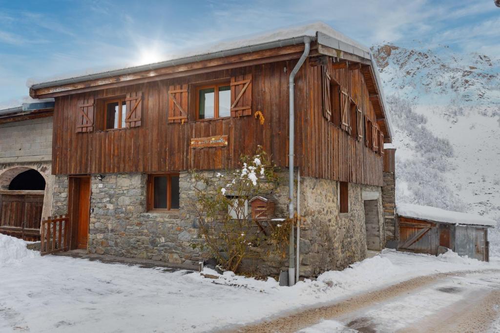 a wooden building with snow on the side of it at Le petit Paradis, chalet au coeur des 3 vallées in Saint-Marcel