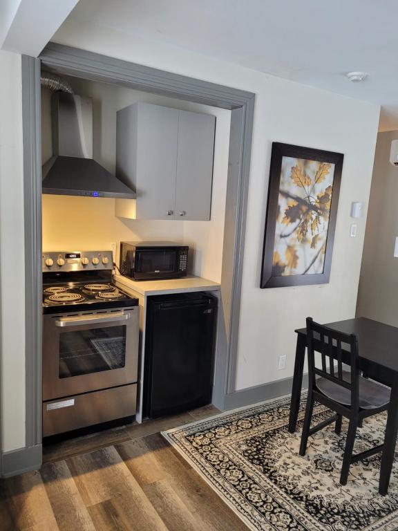a kitchen with a stove and a table with a chair at Oberge Inn Val-David in Val-David