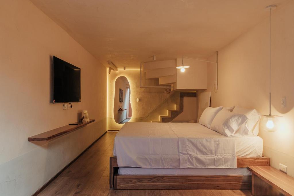 Un dormitorio con una cama blanca y una escalera en NEW Cozy Duplex in Laureles with A/C and WI-FI, en Medellín