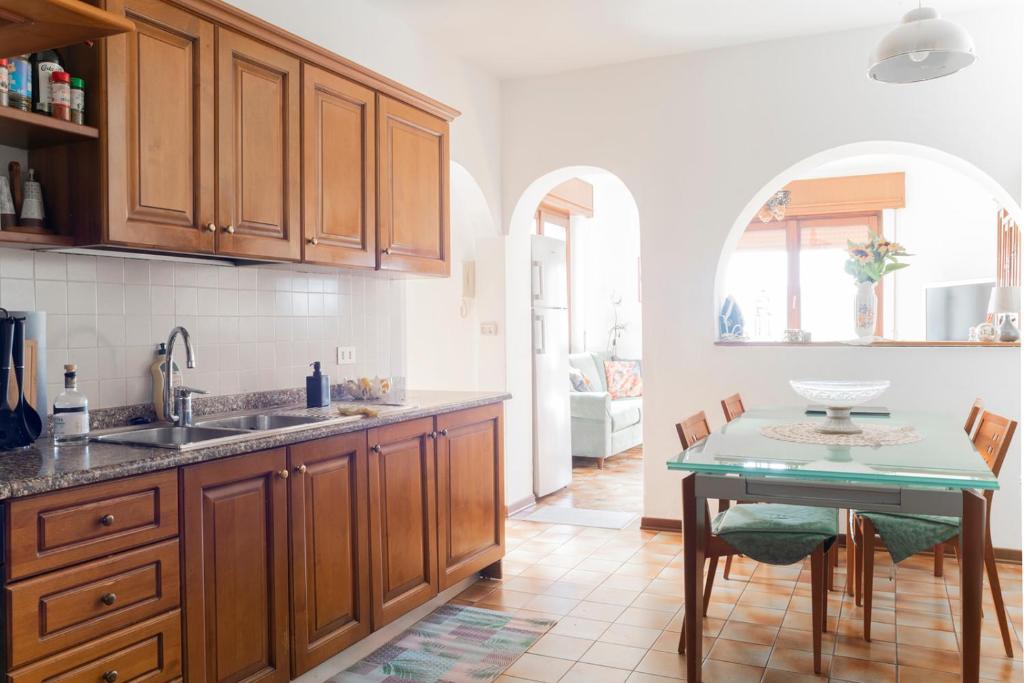 cocina con armarios de madera y mesa en 4 bedrooms home in the countryside - sauna, wine, swim in the creek, en Nimis