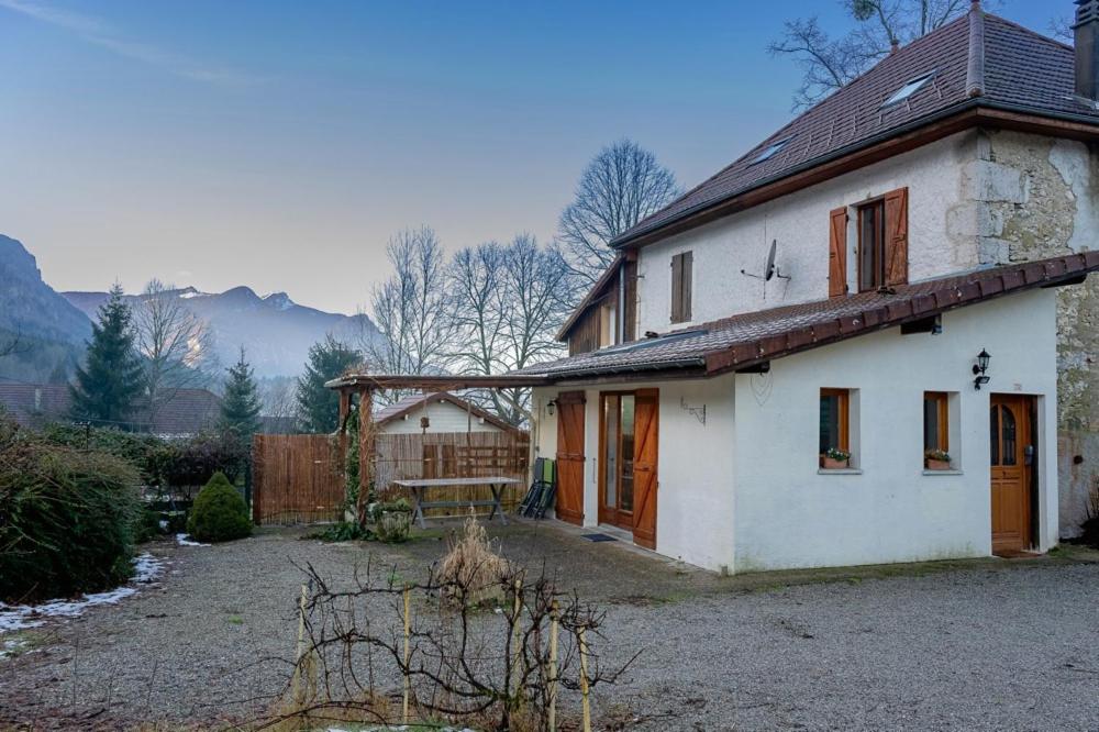 una casa blanca con un patio y una valla en La maison des Jolicoeurs, en Saint-Christophe-sur-Guiers