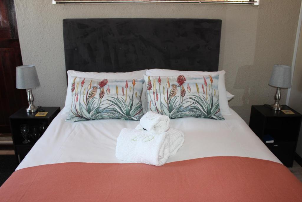 a bedroom with a bed with towels on it at Amru Guesthouse B&B in Brackenfell