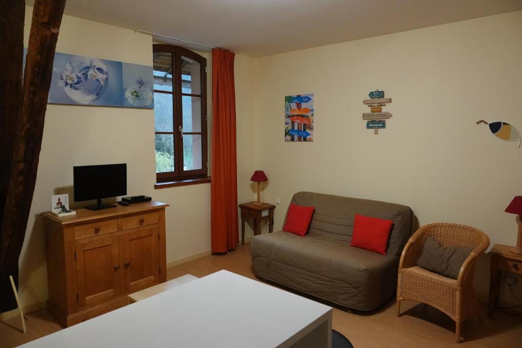uma sala de estar com um sofá e uma televisão em AppT2 Grand-Hôtel: Nature, Randos & Thermes (cure) em Aulus-les-Bains