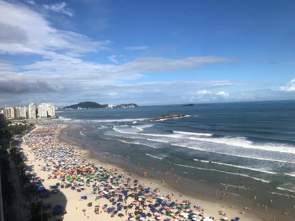Une plage avec beaucoup de gens et l'océan dans l'établissement Guaruja Praia de Pitangueiras frente ao mar, à Guarujá
