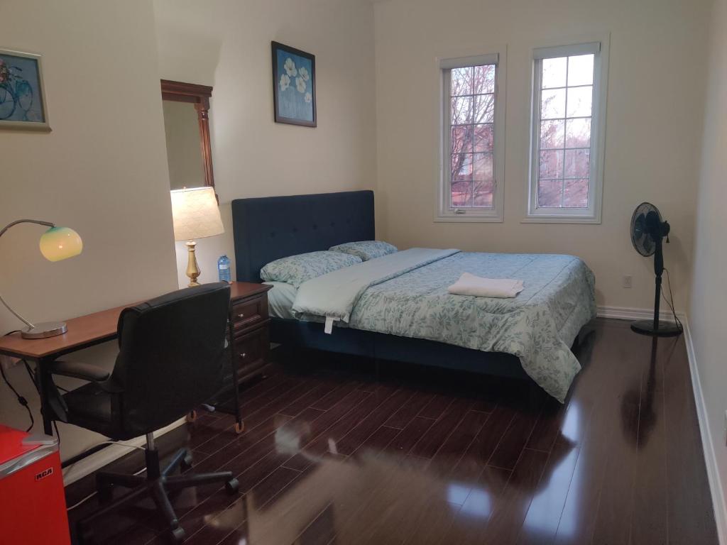 een slaapkamer met een bed, een bureau en een stoel bij Super Huge Comfortable King Bedroom near Toronto Pearson Airport in Mississauga