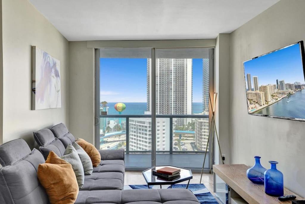 a living room with a couch and a large window at Spacious Luxury Ocean View 4 Bdrs 3Baths 17 FL in Hallandale Beach