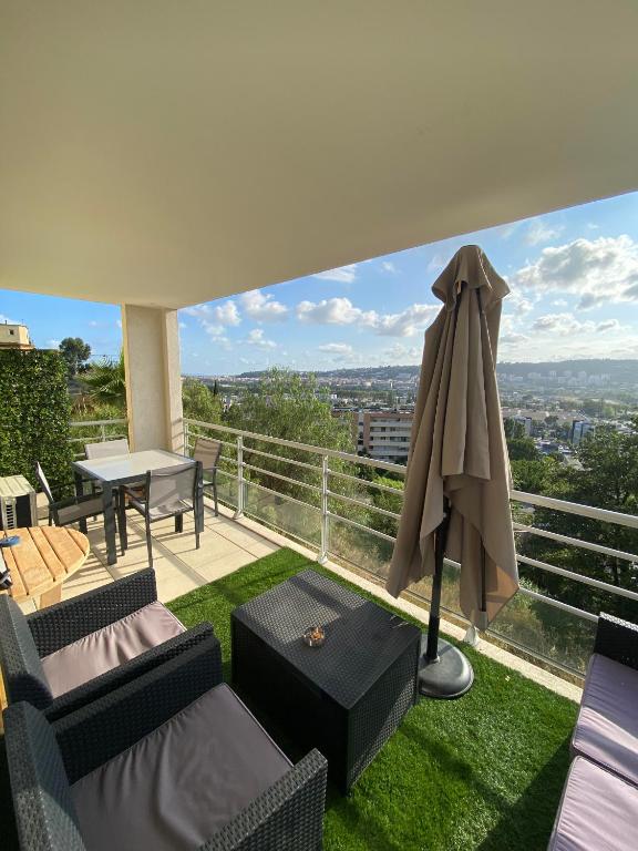 un balcon avec une table et un parasol dans l'établissement Studio cosy, à Nice