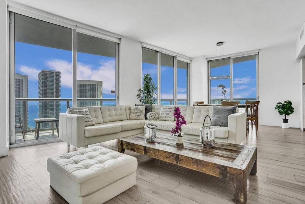 una sala de estar con un sofá y una mesa en Lower Penthouse 3BD 3BA Beach Gym and Pool, en Hallandale Beach
