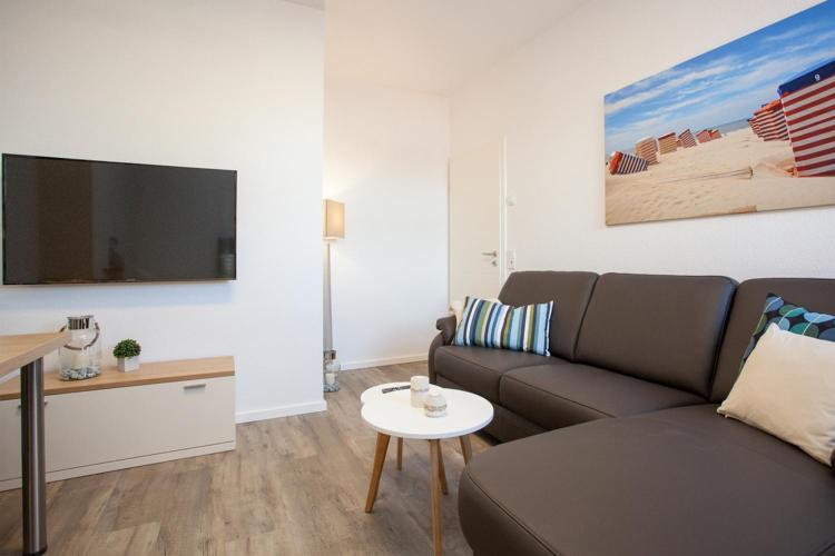 a living room with a couch and a flat screen tv at "Kutje" in der Residenz zum Südstrand in Borkum