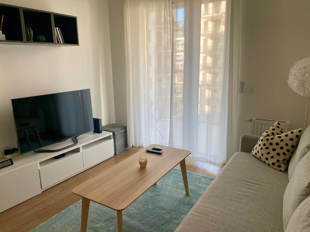 een woonkamer met een tv en een salontafel bij Comfortable place on the Marina port in Boedapest