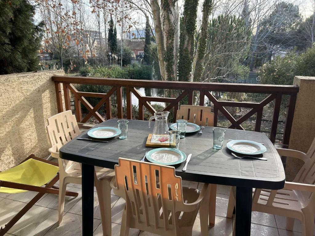 - une table noire avec des chaises et de la nourriture sur la terrasse dans l'établissement Port Camargue: appt 2 pièces 5 pers, parking, terrasse - FR-1-250-199, au Grau-du-Roi