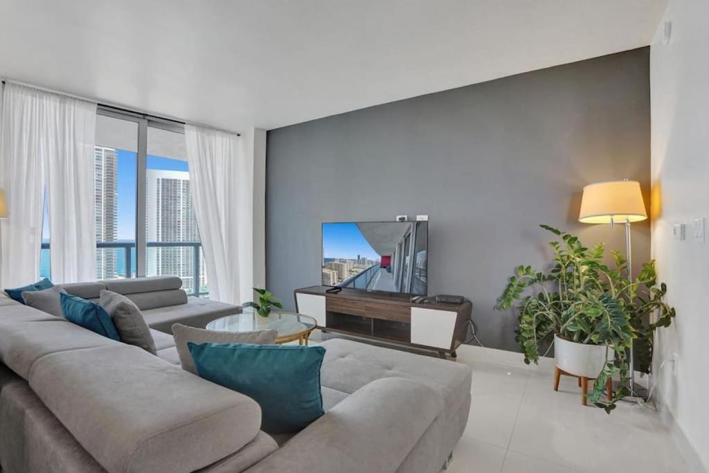 a living room with a couch and a television at Stunning Beach Resort Large 4 Bedrooms Apartment in Hallandale Beach