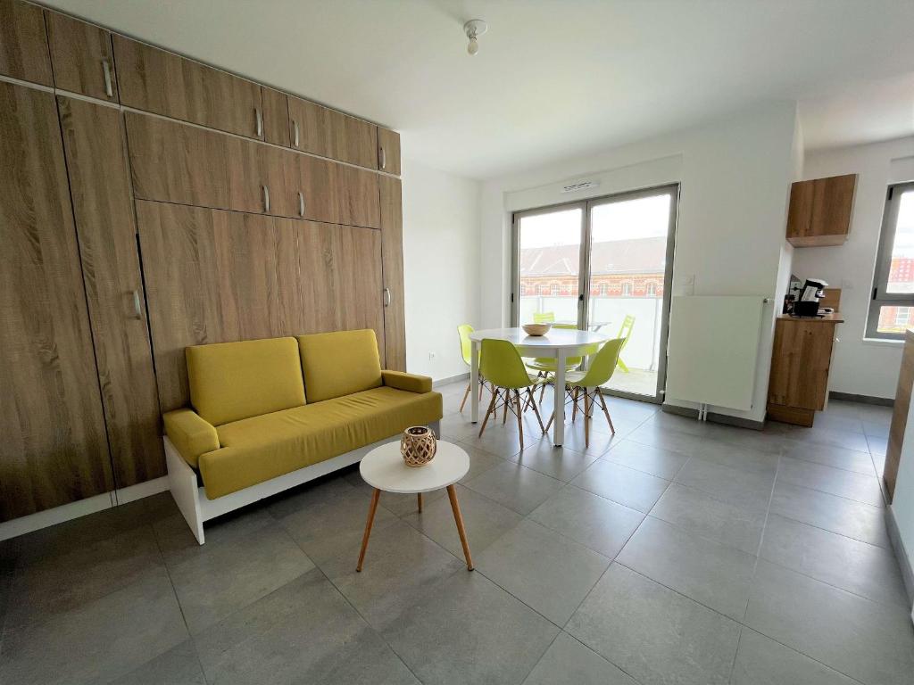 un salon avec un canapé jaune et une table dans l'établissement Studio moderne 30m² avec balcon et parking, accès direct plage et commerces, entièrement équipé. - FR-1-646-11, à Berck-sur-Mer