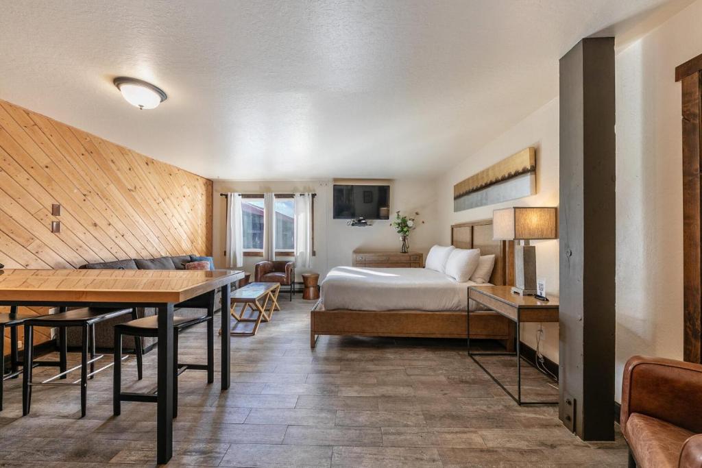 a hotel room with a bed and a table at Lovely Studio w/Kitchen and Partial Lake View #122 at Donner Lake Village in Truckee