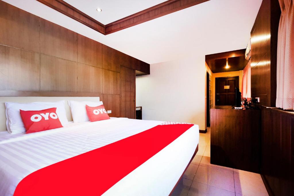 NathonにあるOYO 629 Chaytalay Palace Hotelのベッドルーム1室(大型ベッド1台、赤と白の枕付)
