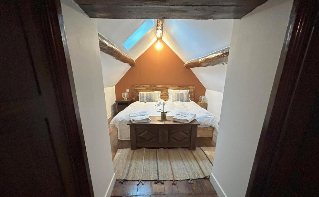 - une chambre mansardée avec un lit et une fenêtre dans l'établissement Domaine Chapelle, à La Chapelle-la-Reine