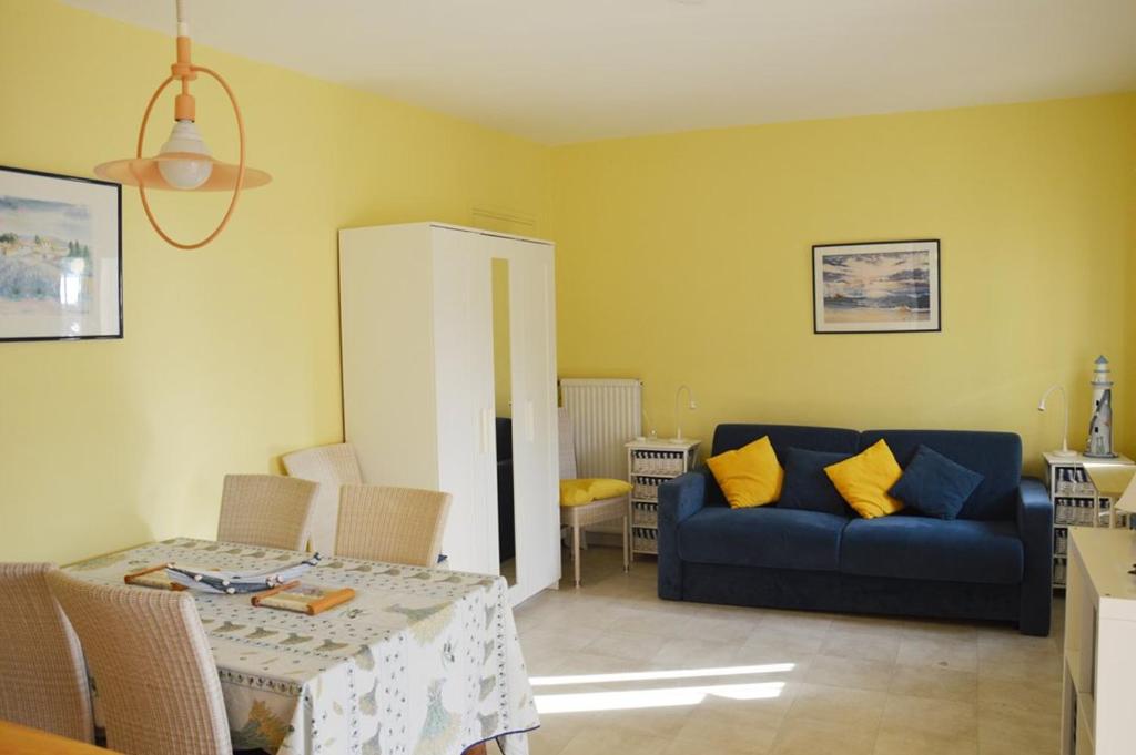 ラ・クロワ・ヴァルメにあるBel appartement 4 pers plage de Gigaro 114のリビングルーム(青いソファ、テーブル付)