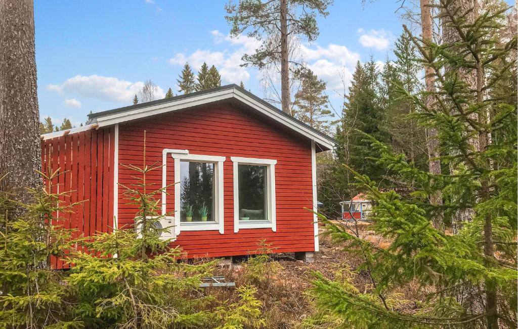 a red tiny house in the middle of a forest at 2 Bedroom Pet Friendly Home In Idkerberget in Idkerberget