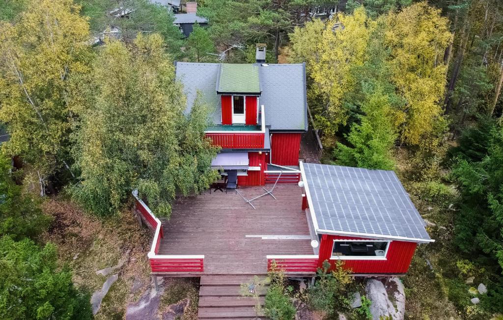 ein rotes Haus mit einer Terrasse und einem Sonnenkollektor in der Unterkunft Pet Friendly Home In Gressvik With House A Panoramic View in Gressvik