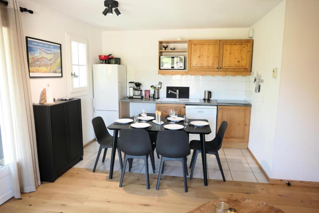 a kitchen with a table with chairs and a refrigerator at Résidence Le Grand Panorama - 2 Pièces pour 6 Personnes 61 in Saint-Gervais-les-Bains