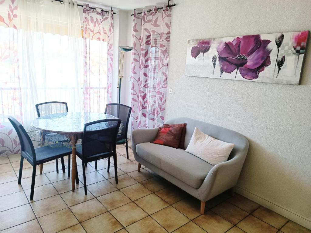 - un salon avec une table, une chaise et un canapé dans l'établissement Résidence Montcalm C - Bel appartement avec Piscine et Tennis ! MAE-6624, à Aix-les-Bains