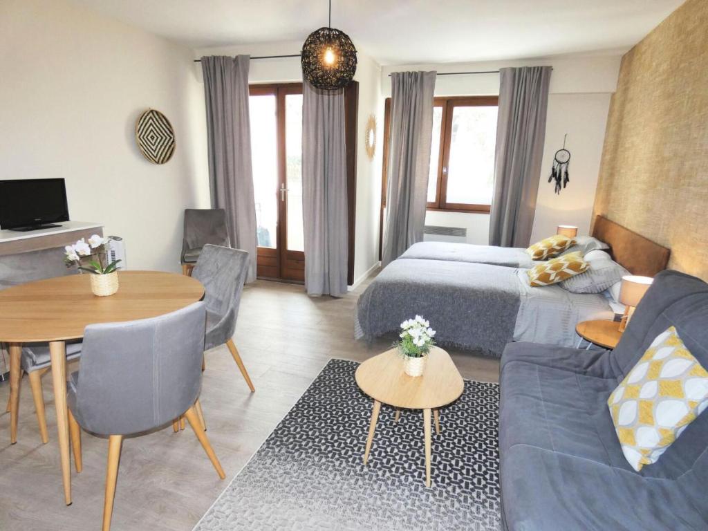 Cette chambre comprend un lit, un canapé et une table. dans l'établissement Résidence Le Chateau Durieux 2 - Coup de coeur pour ce joli logement relooké ! MAE-6654, à Aix-les-Bains