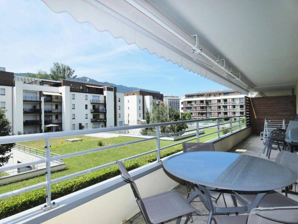 - un balcon avec une table, des chaises et des bâtiments dans l'établissement Residence Les Aiguieres - Idéalement situé sur les Bord du lac, agréable 3 pièces ! MAE-6384, à Aix-les-Bains