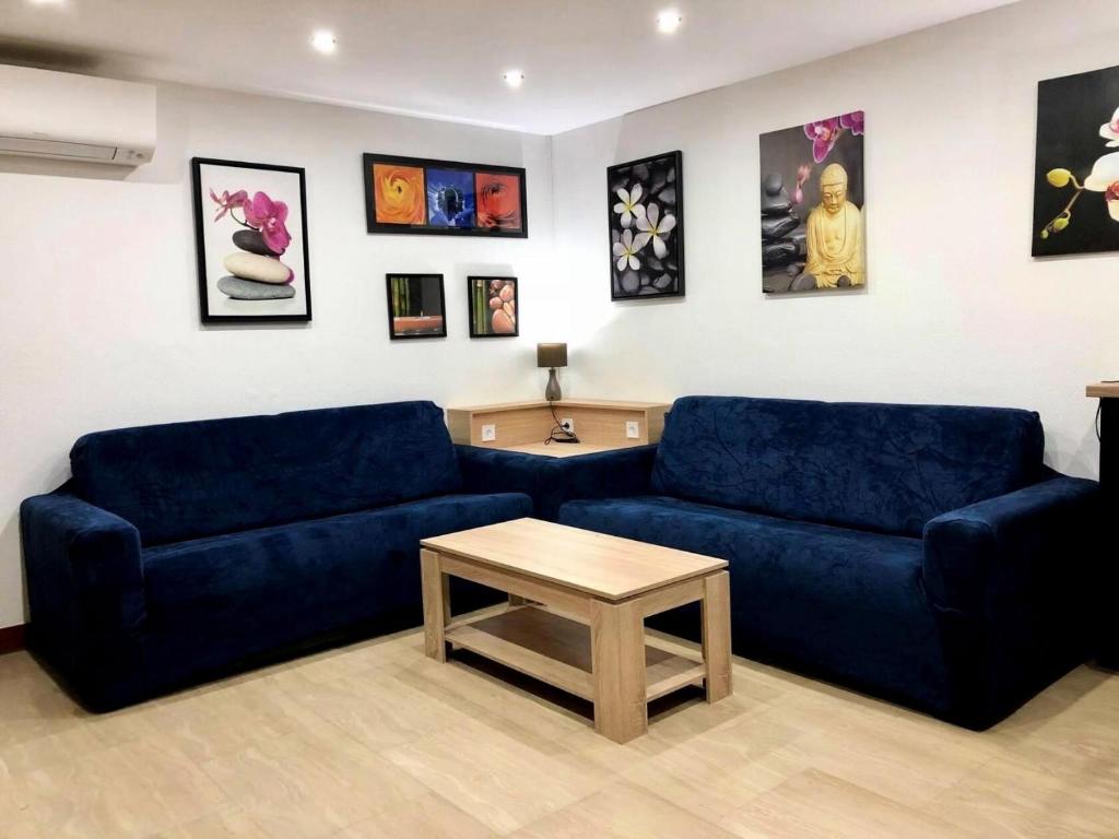 - un salon avec deux canapés bleus et une table basse dans l'établissement Résidence Le Constellation - Très fonctionnel pour ce joli appartement ! MAE-6614, à Aix-les-Bains