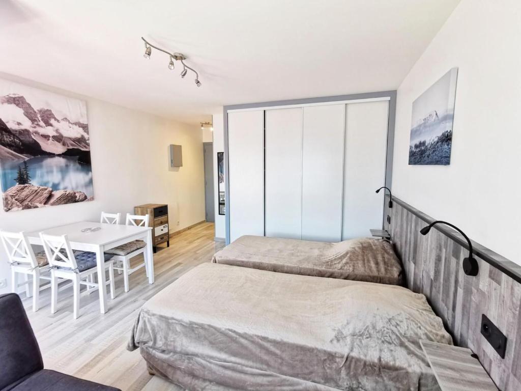 - une chambre avec 2 lits et une table à manger dans l'établissement Résidence Le Chateau Durieux 4 - Coup de coeur pour ce petit studio entièrement relooké ! MAE-7184, à Aix-les-Bains