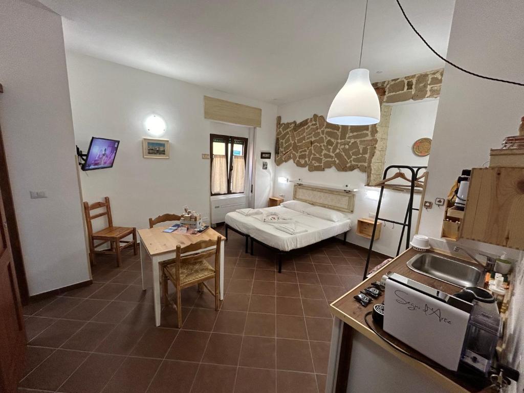 a kitchen and a living room with a bed and a table at Aigua in Alghero