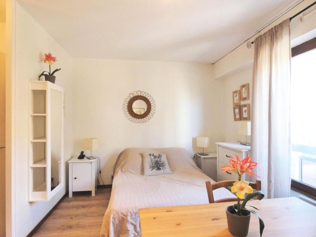 une petite chambre avec un lit et une table dans l'établissement Résidence Le Chateau Durieux 3 - Très mignon studio ! MAE-7174, à Aix-les-Bains