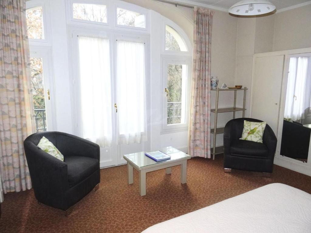 une pièce avec deux chaises, une table et un lit dans l'établissement Residence Albion - Agréable logement avec belle vue sur Parc Boisé ! MAE-7514, à Aix-les-Bains