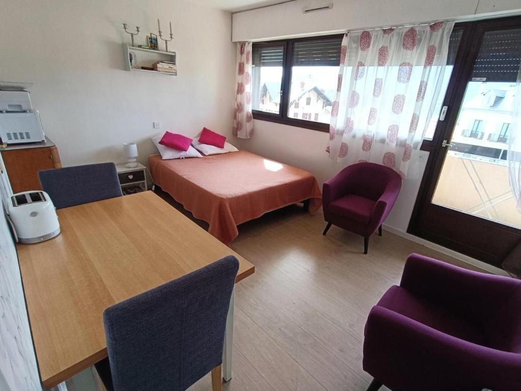 une petite pièce avec un lit, une table et des chaises dans l'établissement Résidence Saint Christophe - Sur les hauteurs de la ville, Ravisant studio ! MAE-7644, à Aix-les-Bains