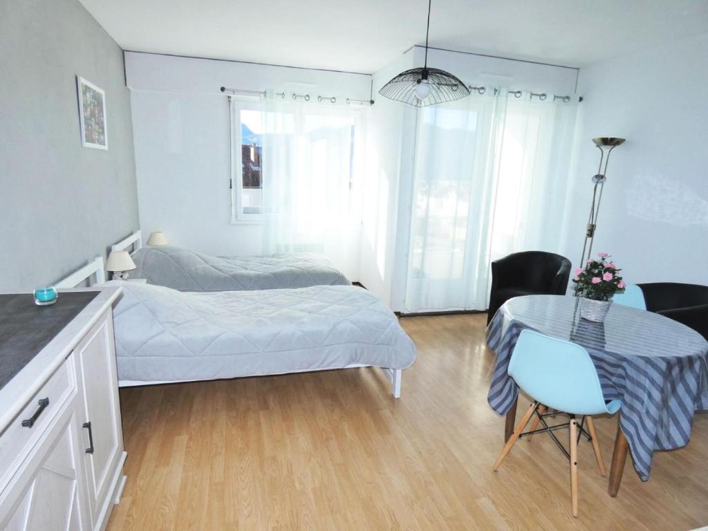 une chambre avec un lit, une table et des chaises dans l'établissement Résidence Le Chateau Durieux 2 - Agréable studio 2 personnes ! MAE-7344, à Aix-les-Bains