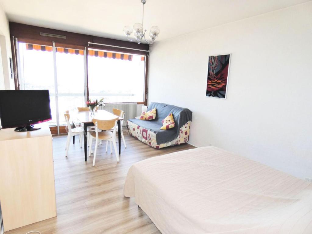 une chambre avec un lit, une chaise et une table dans l'établissement Résidence Le Cheverny - Proche Parc Boisé, agréable appartement 2 personnes ! MAE-7664, à Aix-les-Bains