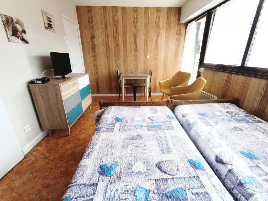 - une chambre avec 2 lits, une télévision et un bureau dans l'établissement Résidence Saint Christophe - Studio agréable et ensoleillé et proche de la cure ! MAE-7764, à Aix-les-Bains